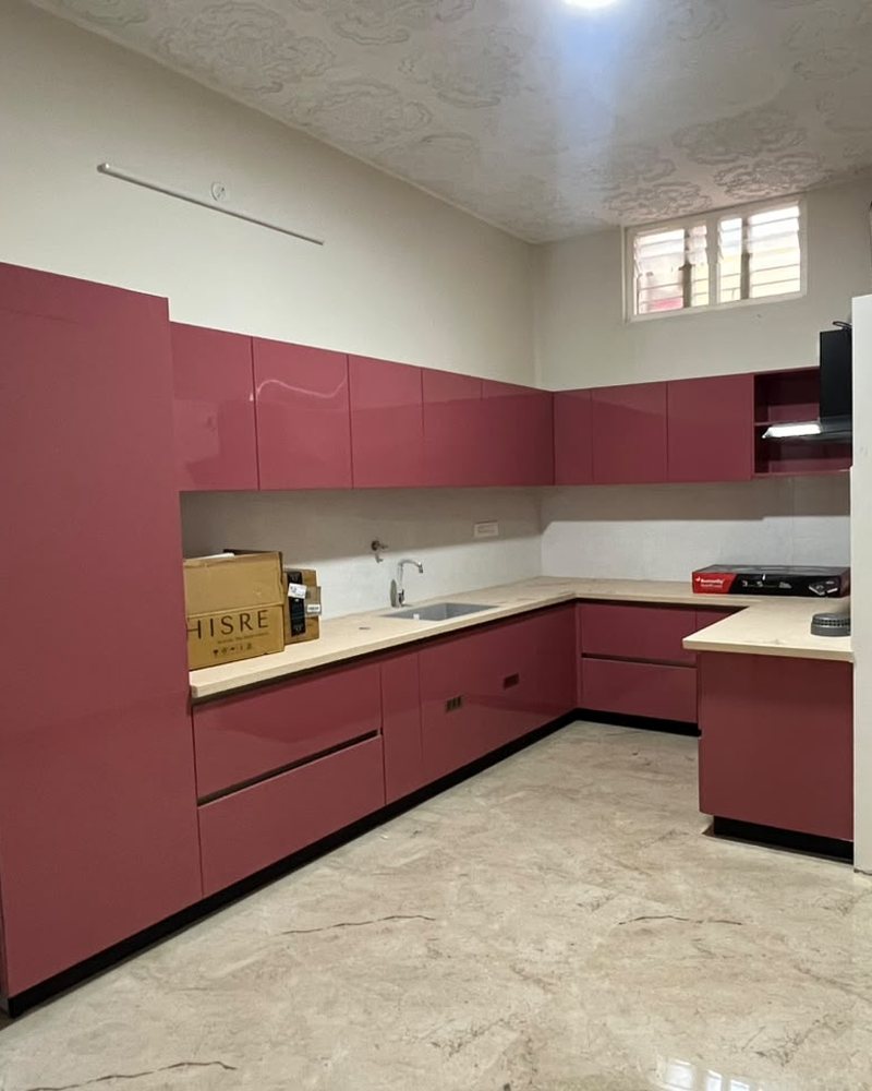 L-shaped kitchen with maroon cabinets and a light worktop