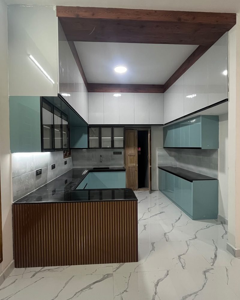 Kitchen with teal cabinets, island counter and marble-look flooring