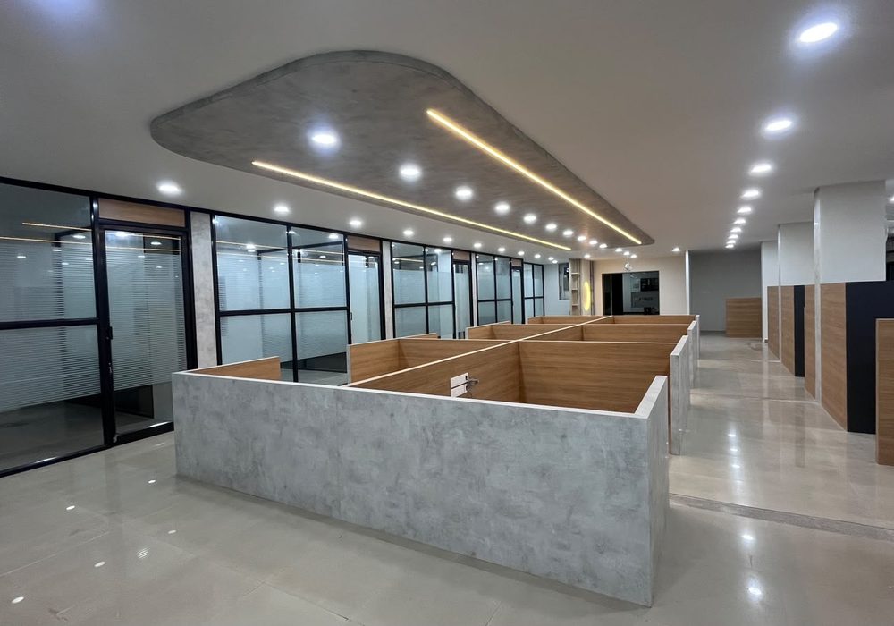 Open-plan office with a feature false ceiling, linear lighting and glass partitions