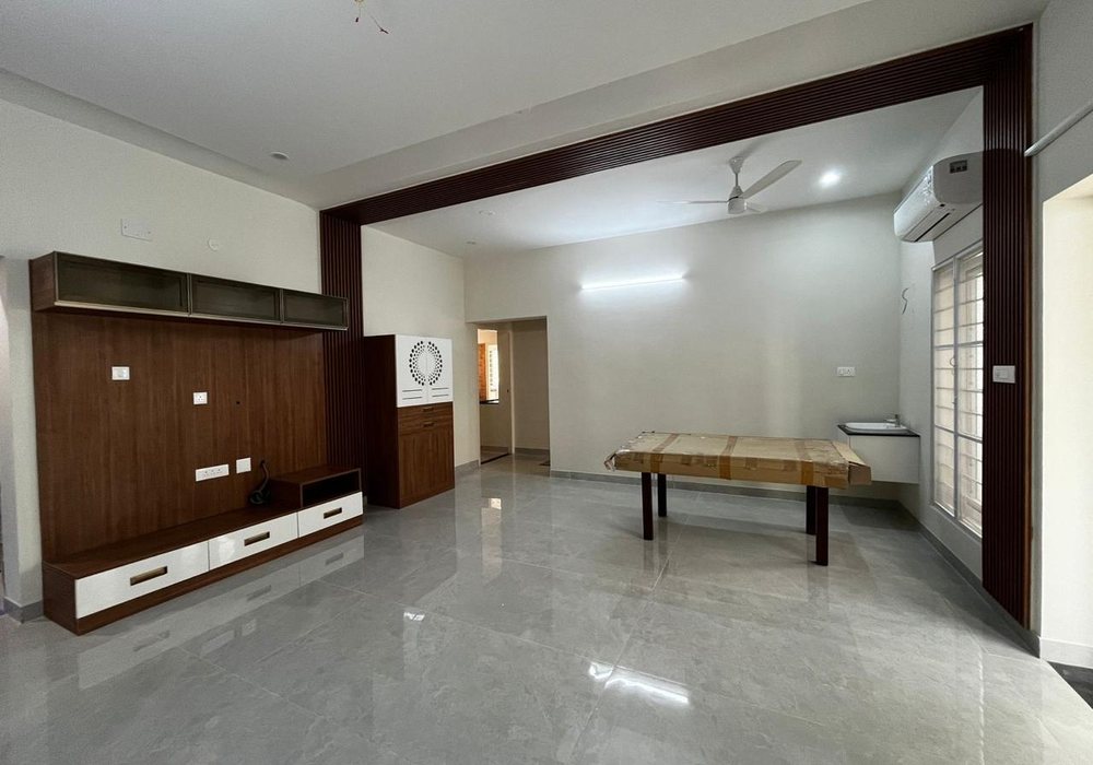 Living room with a wall-mounted TV unit, a pooja unit and a wood-slat arch