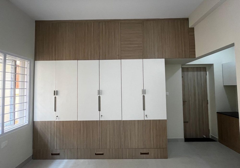 Floor-to-ceiling wardrobe wall in wood and white finishes